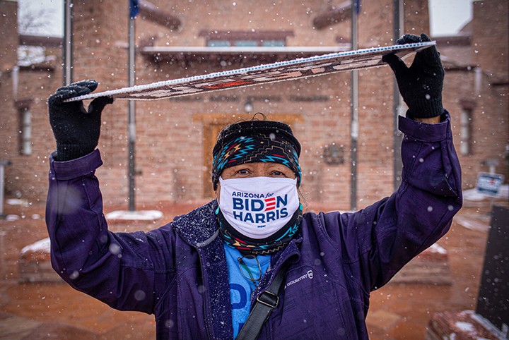 Sharon Chischilly for the Navajo Times Biden/Harris supporter Cindy Honani stands outside the Navajo Nation Council Chamber while holding a sign above her head to protect herself from the snow in Window Rock in late October.