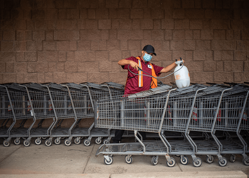 Sharon Chischilly for The New York Times Cordaryll Tolino disinfecting shopping carts at Bashas’ Diné Market in Window Rock. Native American communities have consistently had higher positivity rates than the general population.